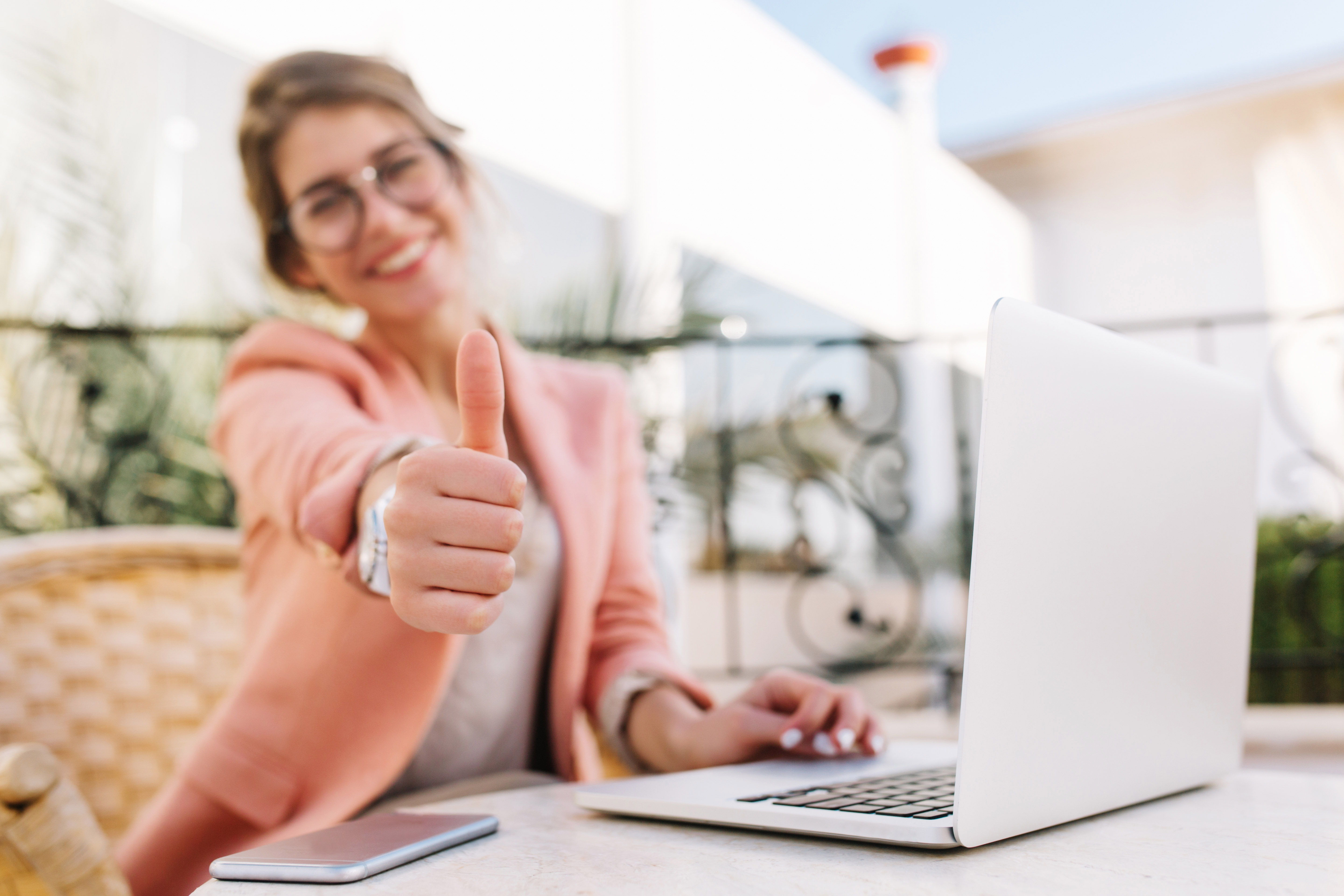 woman sitting in front of her computer giving a thumbs up