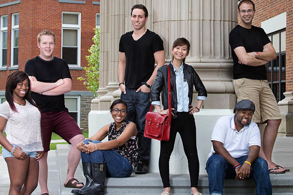 Diverse students sit on the steps outside Hegeman Hall